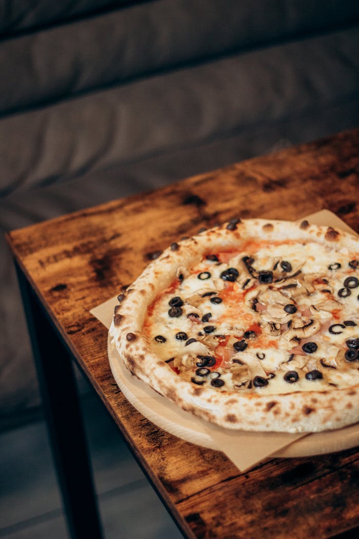 Mastering the First Impression: Your intriguing post title goes here Freshly baked pizza topped with mushrooms and olives served on a rustic table.